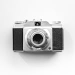 Close-up of a vintage camera on a white background, perfect for photography enthusiasts.
